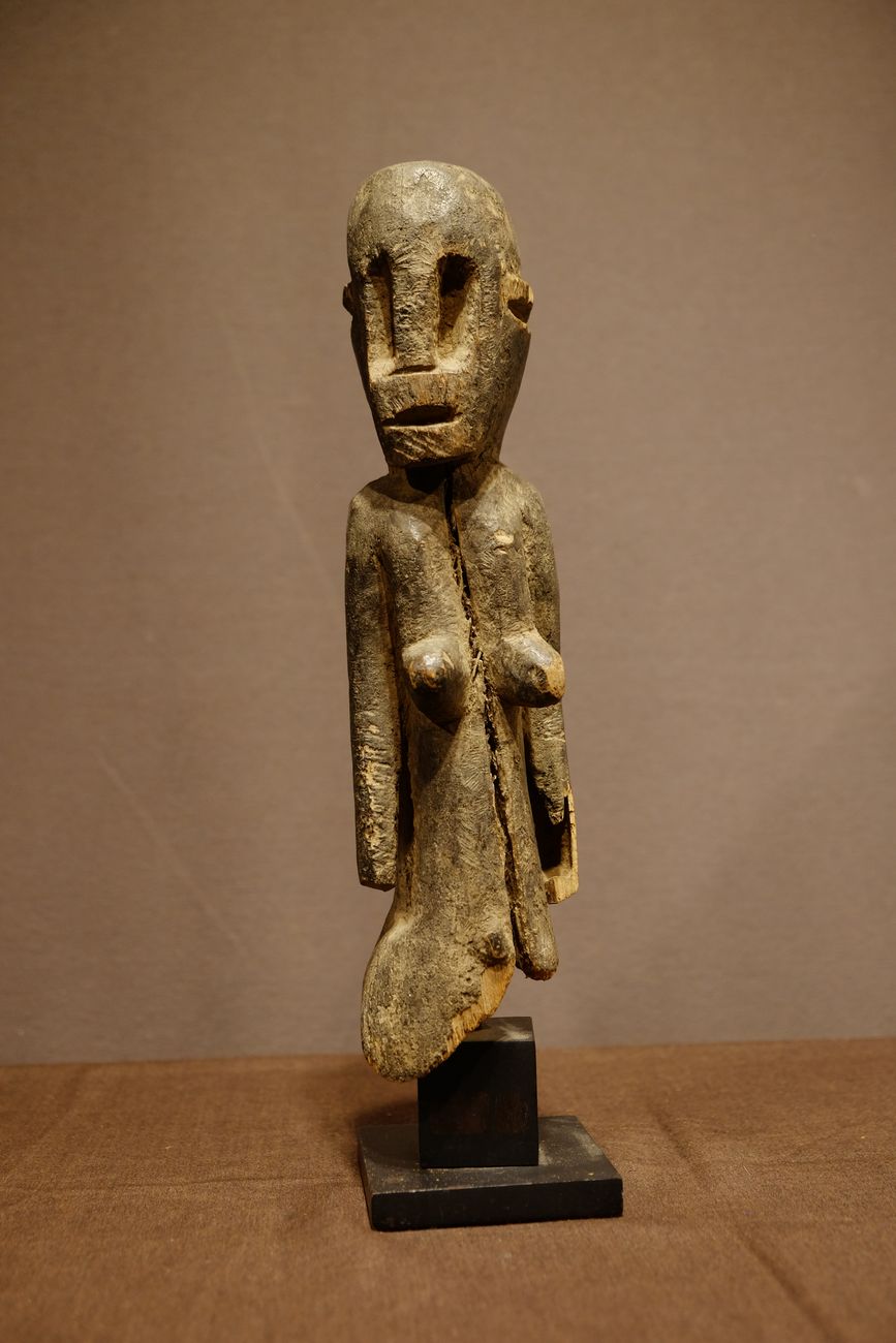 A Dogon figure wearing a Mask